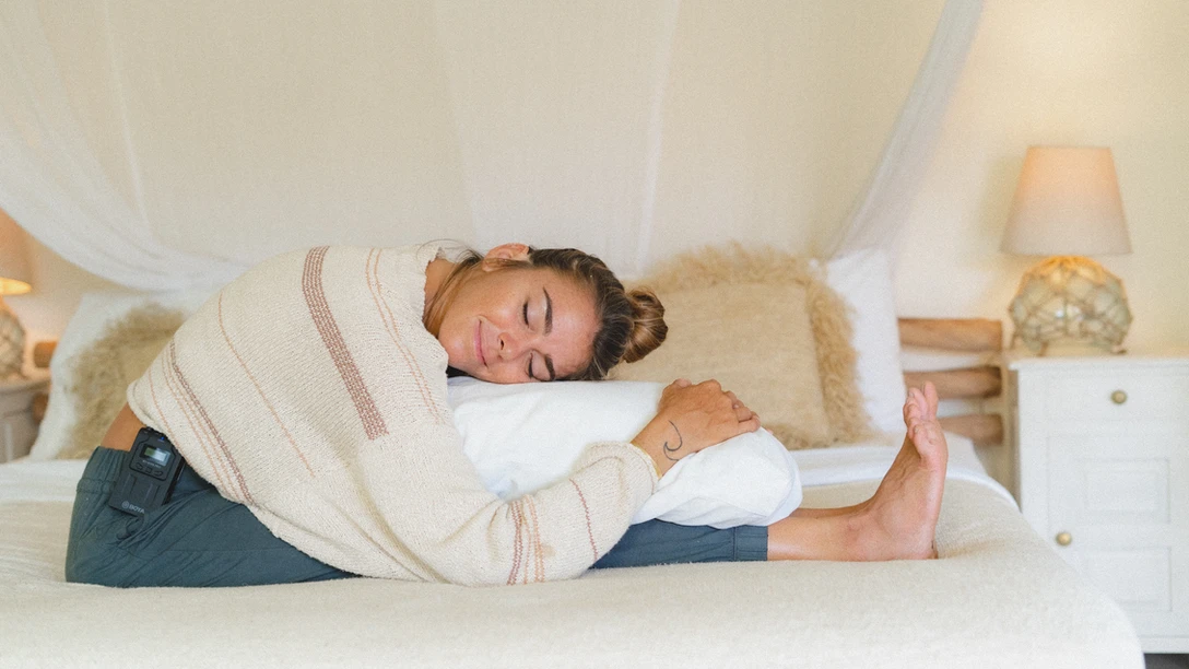 A person leaning forward on a pillow in a meditative state